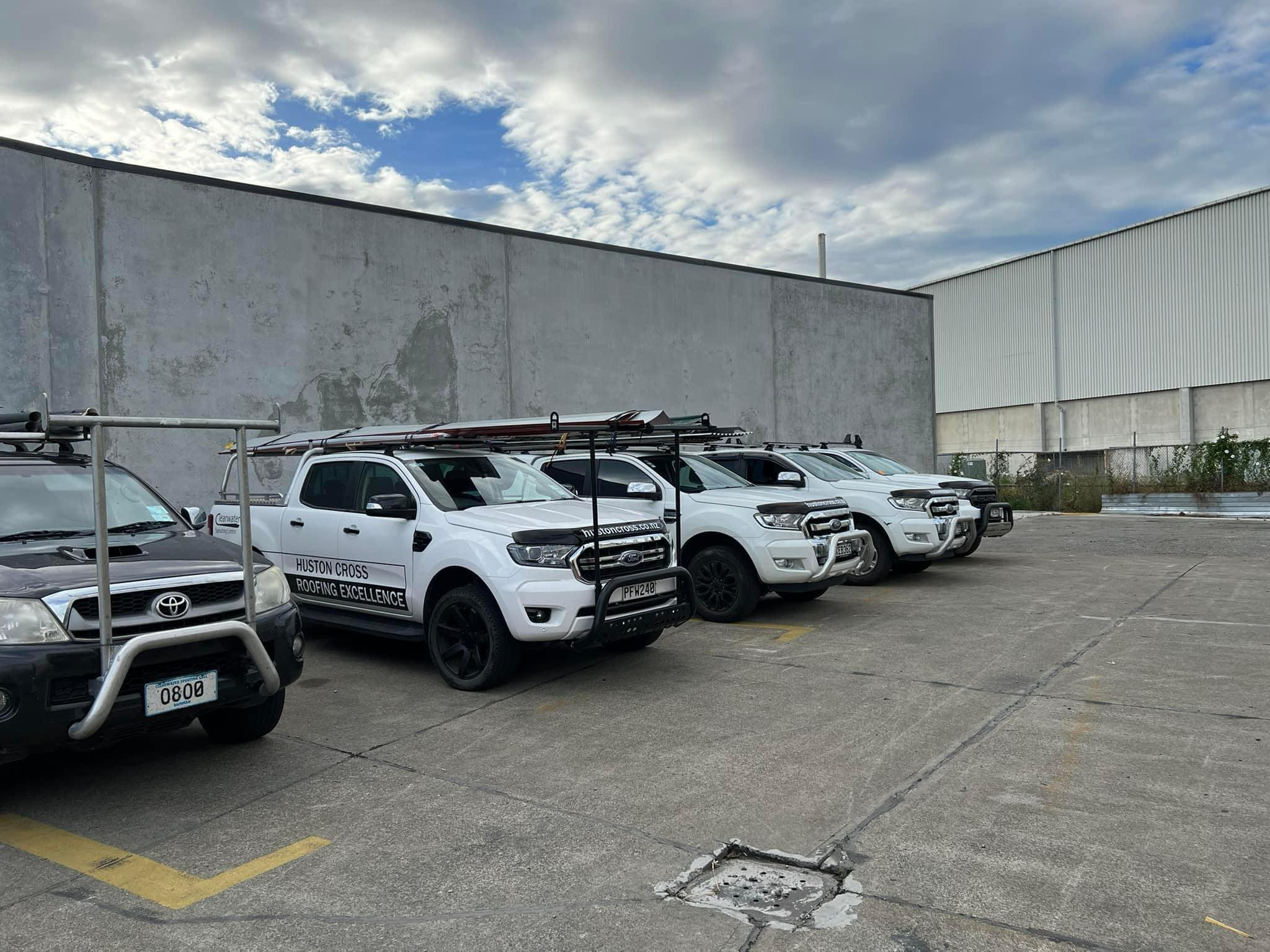 Huston Cross roofing vehicles parked at the Christchurch yard, representing a professional local roofing company and its experienced team