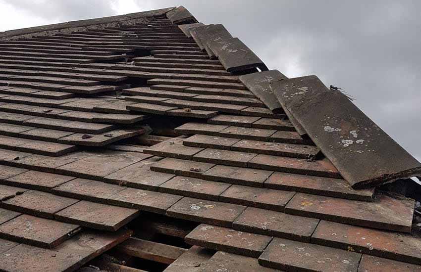 Storm-damaged tiled roof with slipped and missing tiles, showing the kind of damage that may lead to a roof insurance claim in Christchurch